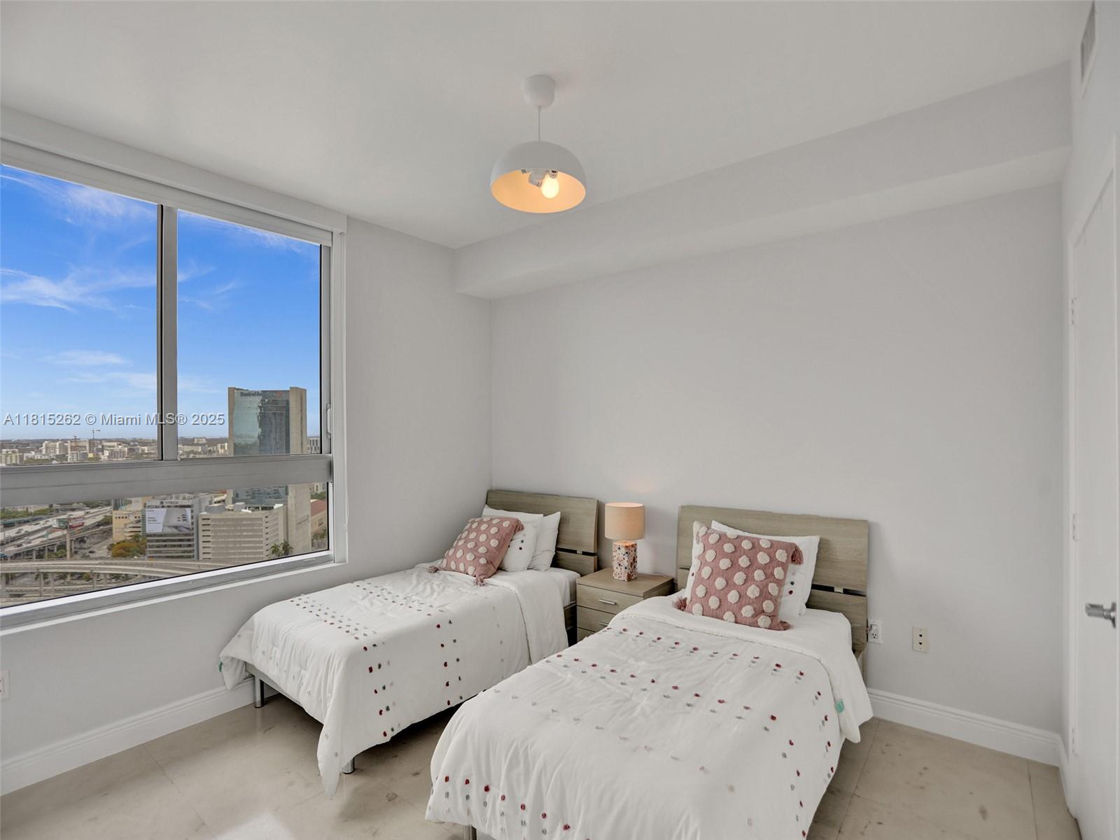 90 Southwest 3rd Street, Unit 2809 Miami, FL 33130 - Photo 24 of 67 a bedroom with two beds and a large window
