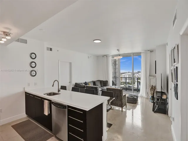 a living room with furniture a floor to ceiling window and rug