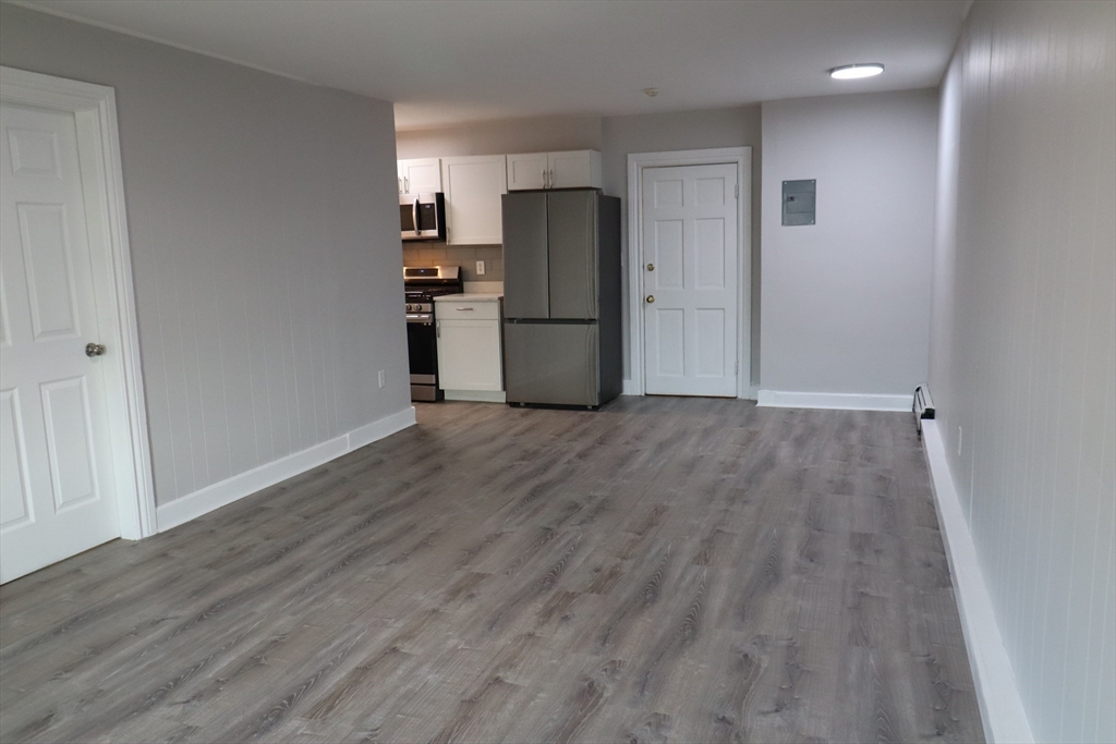 7 High Street, Unit 11 Clinton, MA 01510 - Photo 11 of 17 a view of a kitchen with wooden floor and a refrigerator