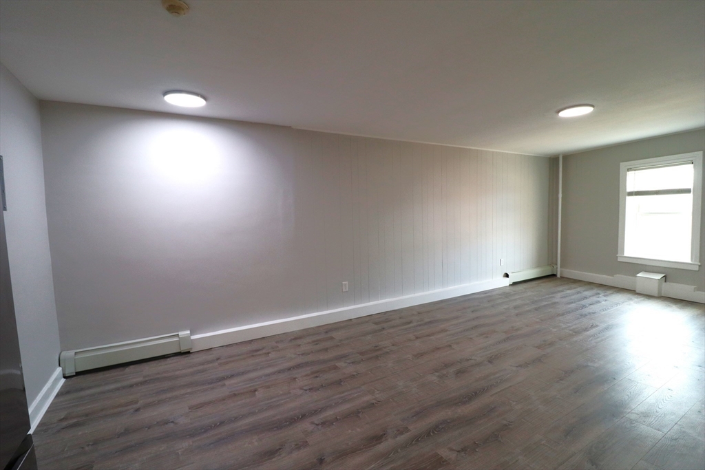 7 High Street, Unit 11 Clinton, MA 01510 - Photo 9 of 17 an empty room with wooden floor and windows
