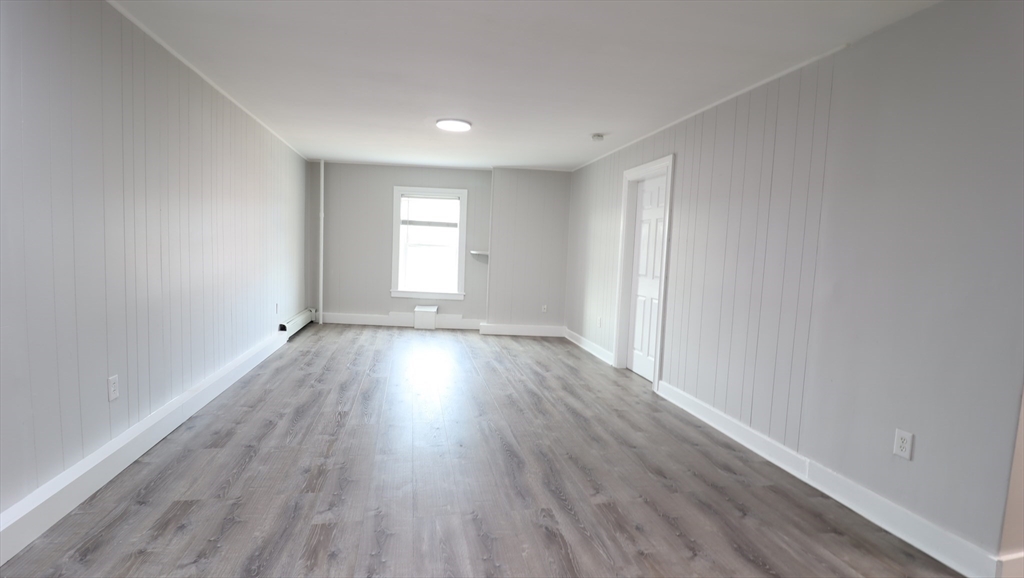 7 High Street, Unit 11 Clinton, MA 01510 - Photo 10 of 17 wooden floor in an empty room with a window