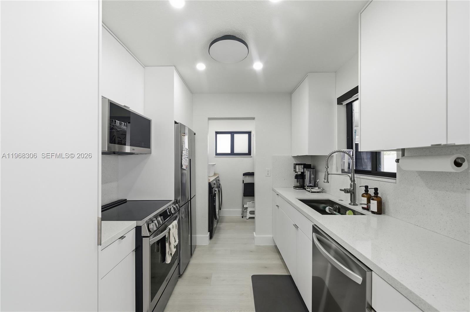 7491 Raleigh Street Hollywood, FL 33024 - Photo 11 of 28 a kitchen with stainless steel appliances granite countertop a sink stove and refrigerator