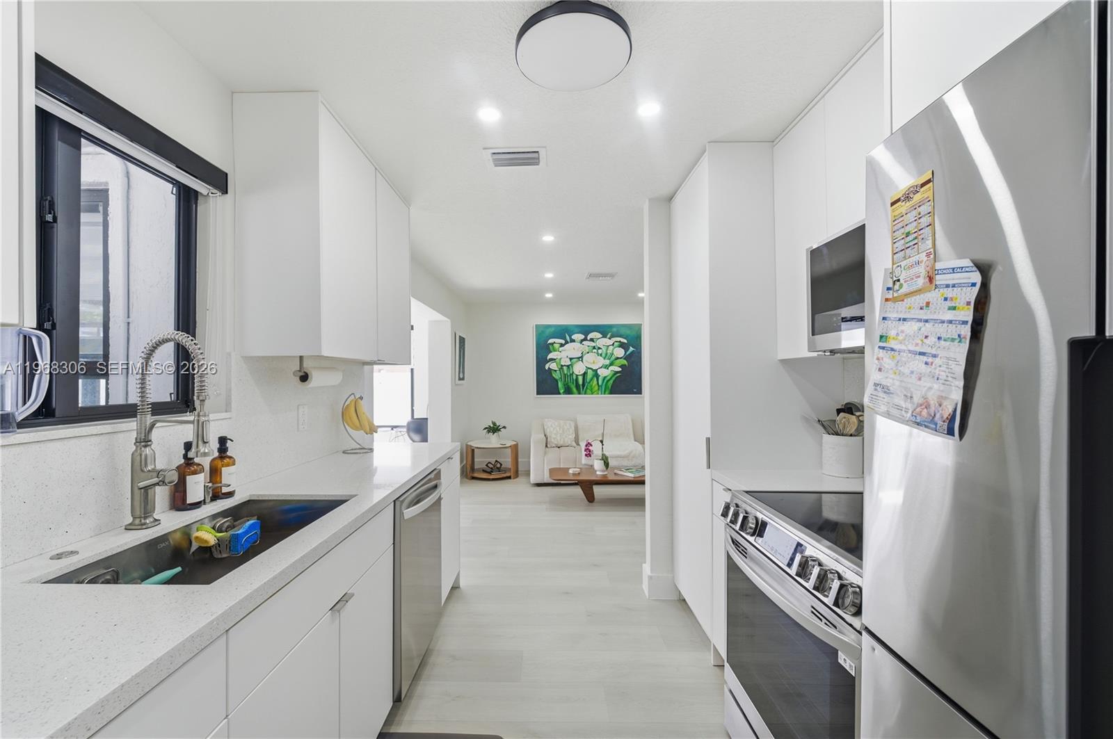 7491 Raleigh Street Hollywood, FL 33024 - Photo 13 of 28 a kitchen with stainless steel appliances a sink stove and cabinets