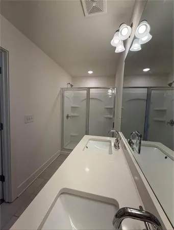 a bathroom with a sink double vanity granite tub and shower