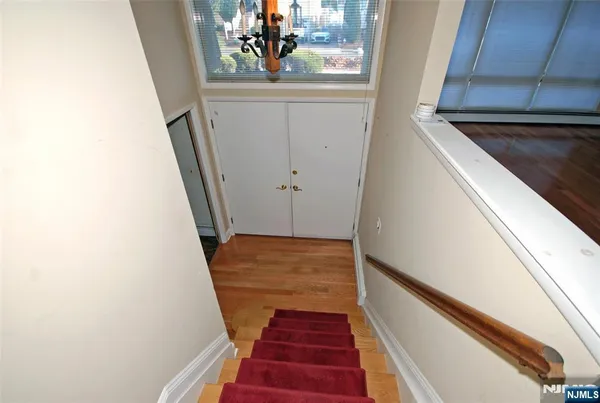 a view of a hallway with wooden floor and stairs