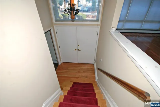 a view of a hallway with wooden floor and stairs