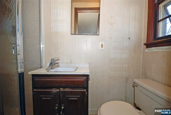 a bathroom with a toilet a sink and mirror
