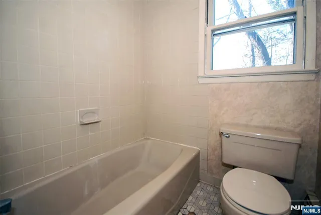 a bath room with a toilet and a bath tub