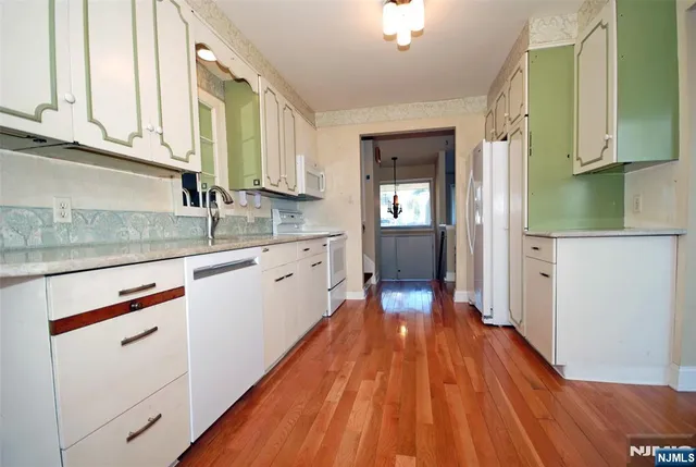 a kitchen with wooden floors appliances