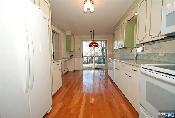 a kitchen with counter top space and wooden floor