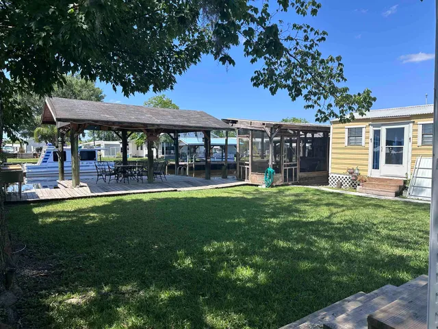 a view of a patio with table and chairs potted plants and large tree