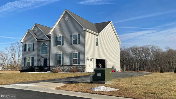 a view of a white house with a yard and large tree