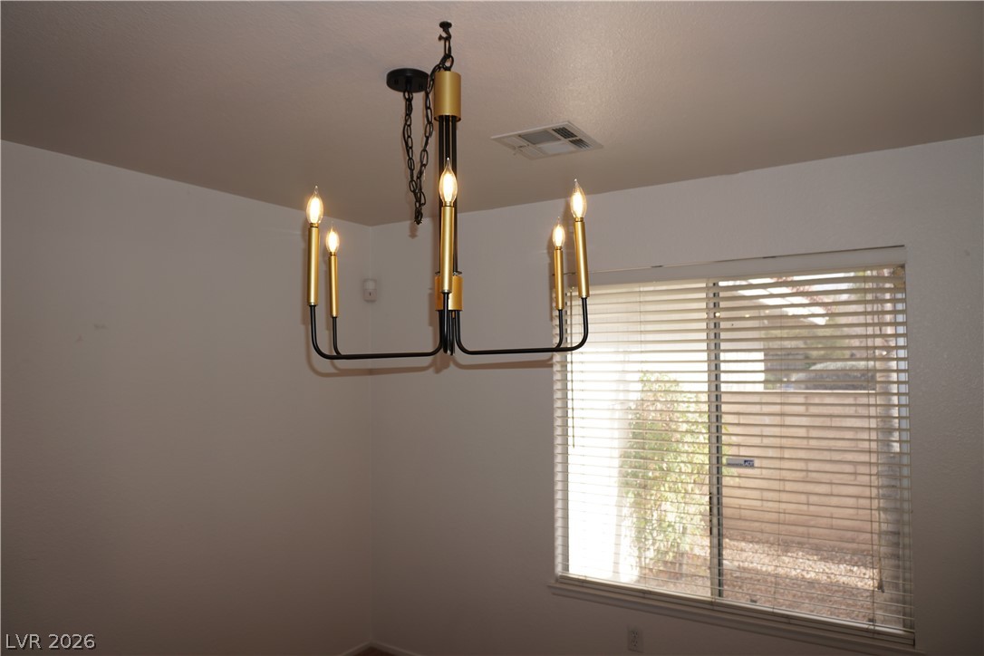 8328 Del Rey Avenue Las Vegas, NV 89117 - Photo 23 of 38 A sleek modern chandelier illuminates this naturally lit room, offering a pleasant ambiance.