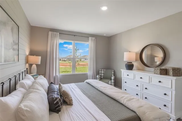a bedroom with a bed mirror and window