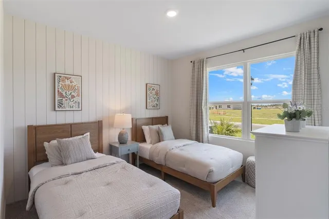 a bedroom with two beds and a large window