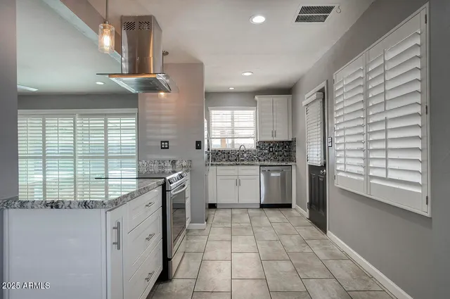 a view of a kitchen with granite countertop a sink and a window