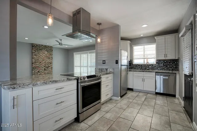 a kitchen with a sink window and stainless steel appliances