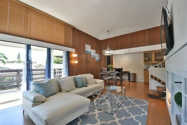 a living room with furniture a fireplace and large windows