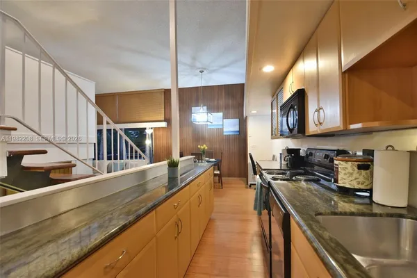 a kitchen with stainless steel appliances granite countertop sink stove and refrigerator