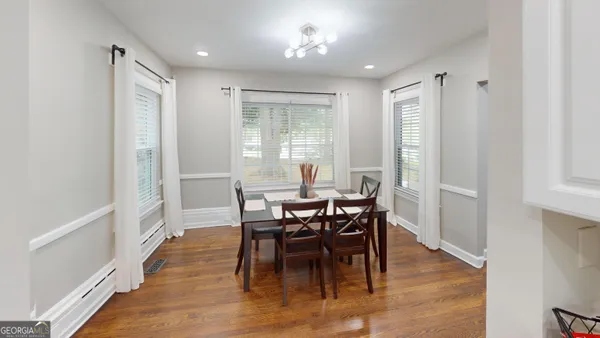 a view of a a dining room with furniture window and wooden floor