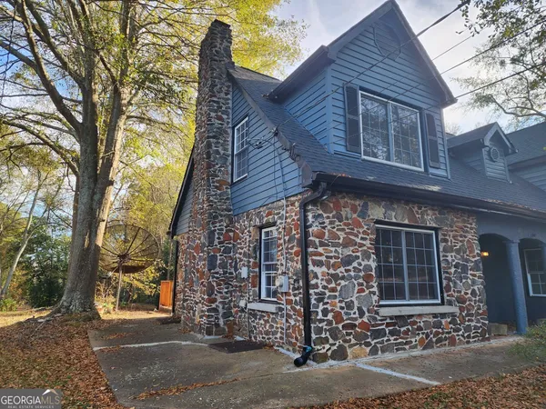 a front view of a house with a tree
