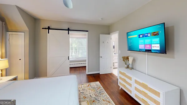 a bedroom with furniture and a flat screen tv