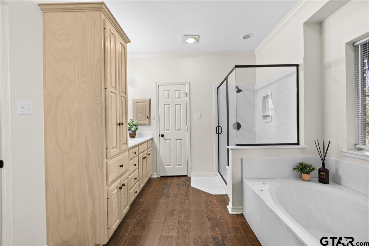 a bathroom with a bathtub a sink and wooden floor