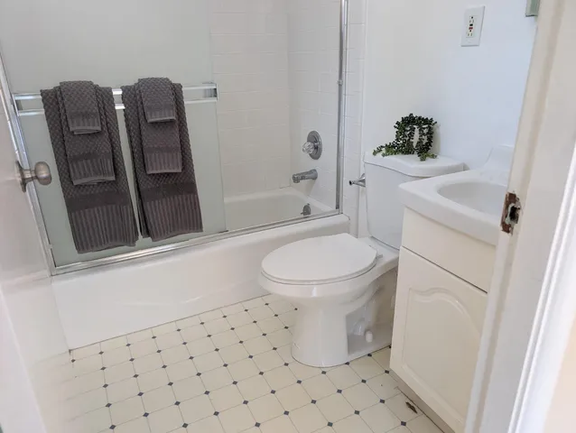 a white toilet sitting next to a bathroom sink and a tub