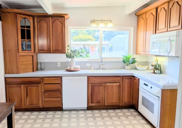 a kitchen with stainless steel appliances granite countertop a sink and a large window