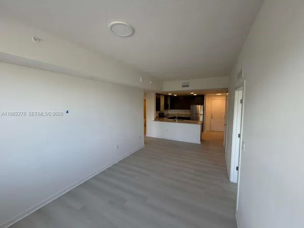 a view of a kitchen with wooden floor electronic appliances and stairs