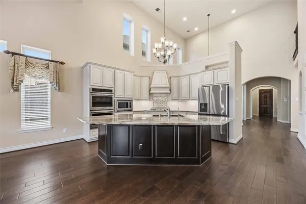 a large kitchen with stainless steel appliances a large center island and a stove top oven