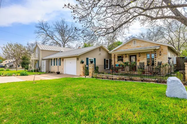 a front view of a house with yard patio and green space