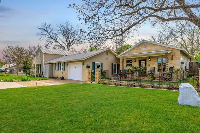 a front view of a house with a yard and trees