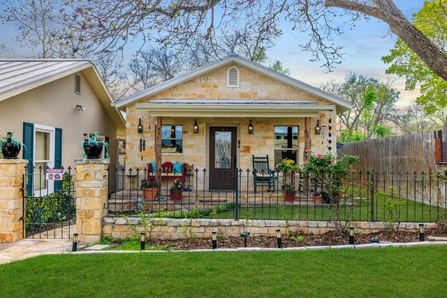 a front view of a house with a yard and potted plants
