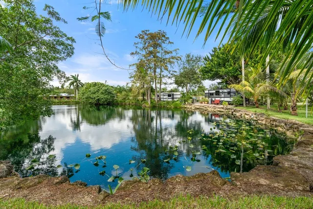 a backyard of a house with lots of green space and lake view