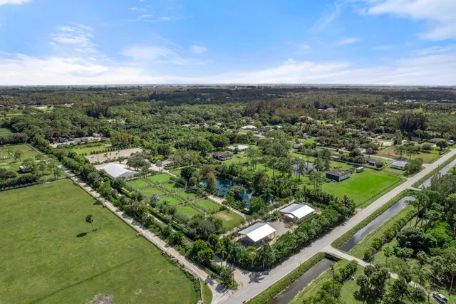 an aerial view of residential houses with outdoor space and trees