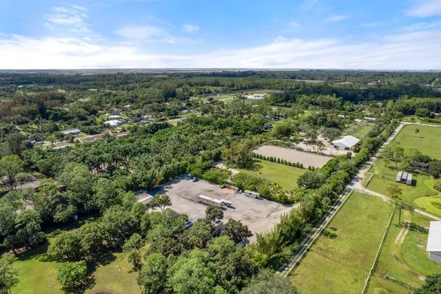 an aerial view of residential houses with outdoor space and trees