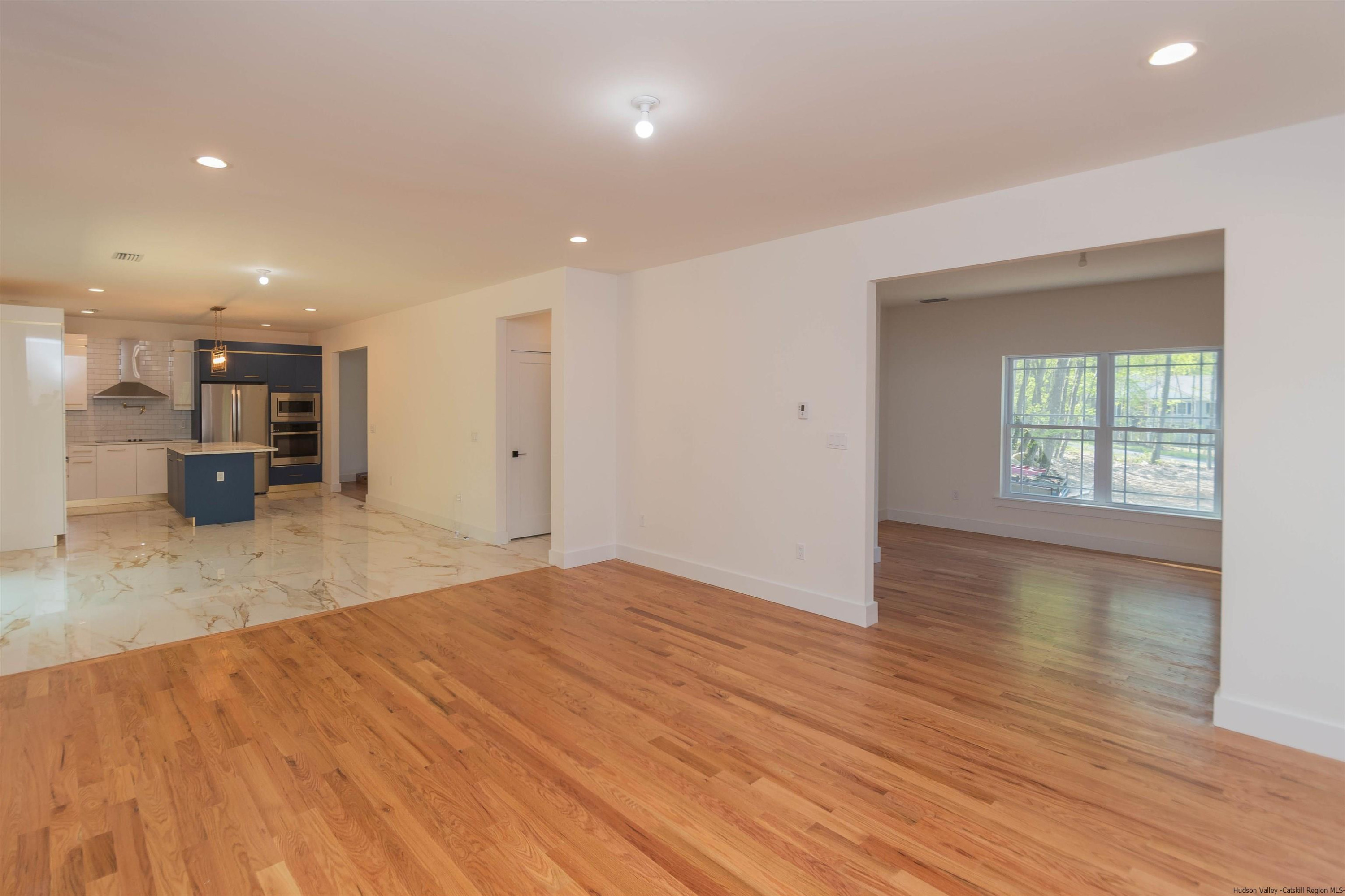 5 Calico Ways Ways, Unit WAYS Wallkill, NY 12589 - Photo 16 of 35 an empty room with wooden floor and a kitchen