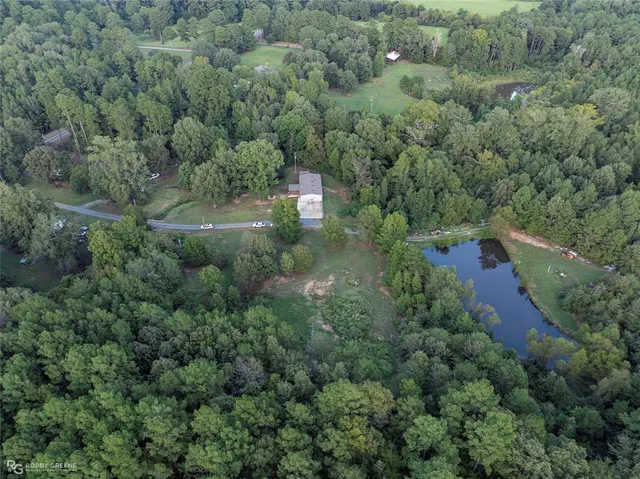an aerial view of a house with a yard and outdoor seating