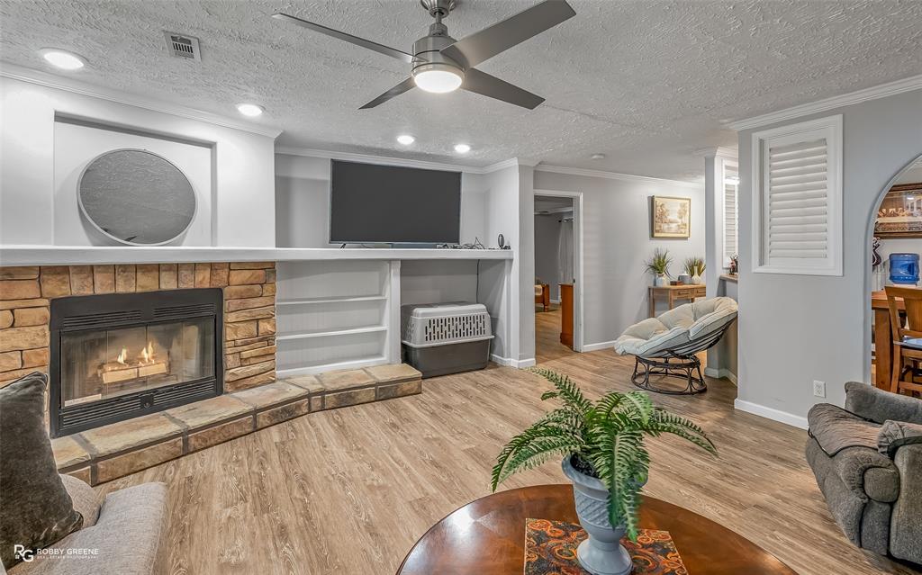 8287 Jefferson Paige Road Shreveport, LA 71119 - Photo 7 of 40 Living area featuring a fireplace, ornamental molding, a textured ceiling, wood finished floors, and recessed lighting