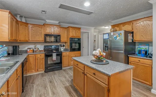 a kitchen with stainless steel appliances granite countertop a stove a sink and a refrigerator