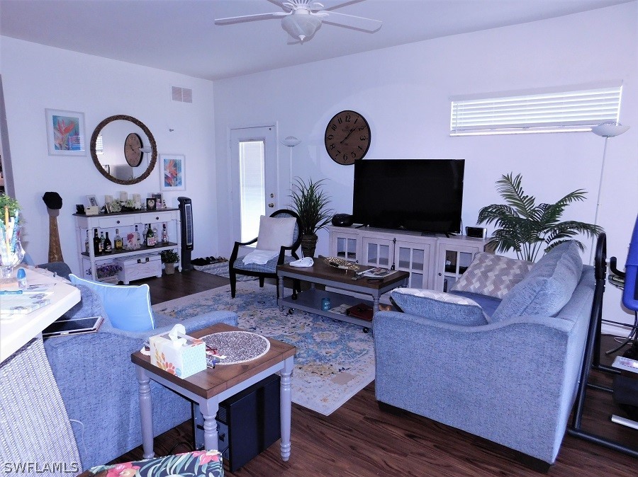 5180 Park Road, Unit 1 Fort Myers, FL 33908 - Photo 8 of 24 a living room with furniture a flat screen tv and a wall clock