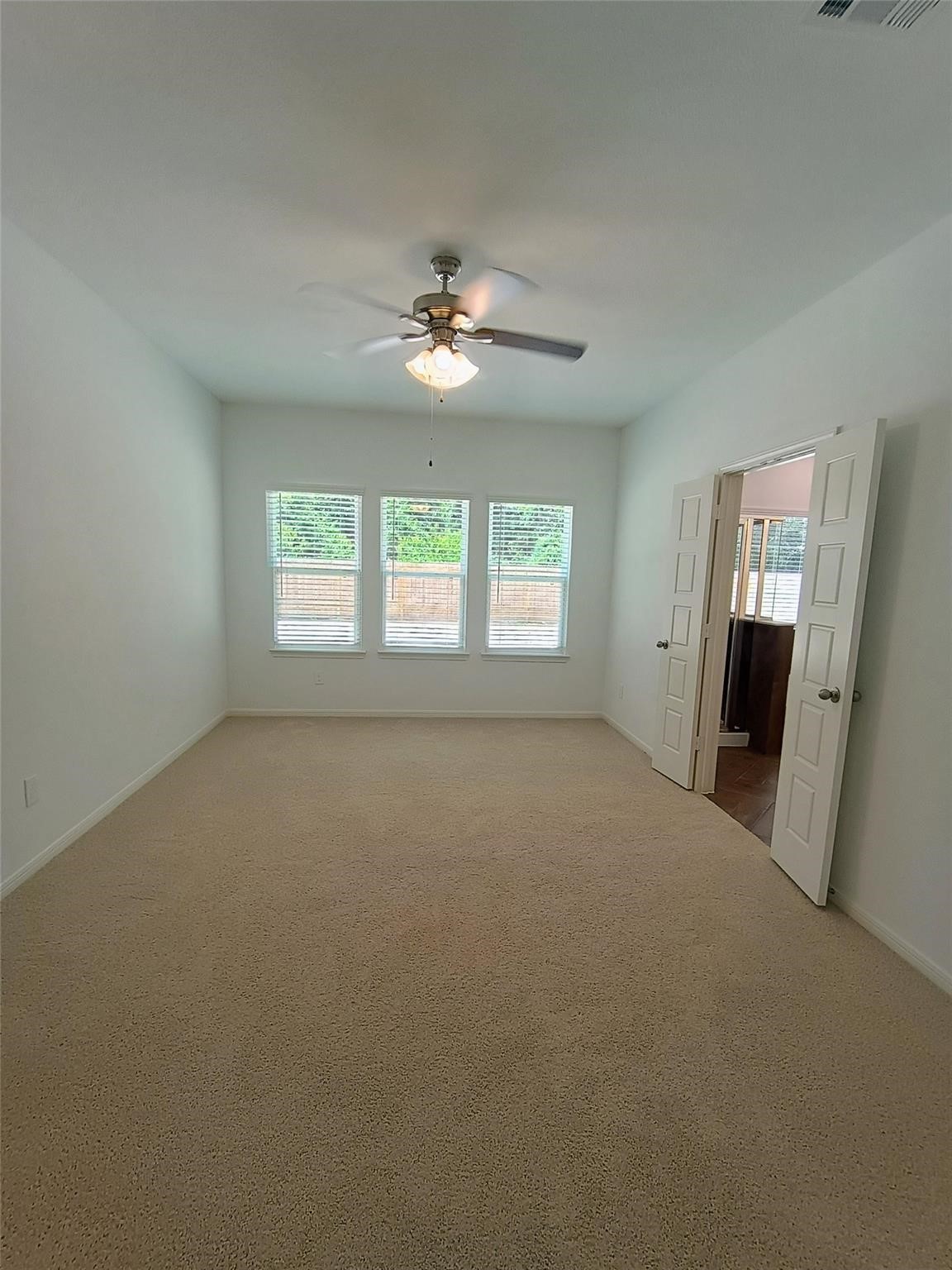 15924 Cy Young Court Splendora, TX 77372 - Photo 12 of 29 an empty room with windows and fan