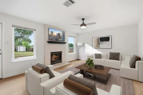 a living room with furniture a fireplace and a flat screen tv