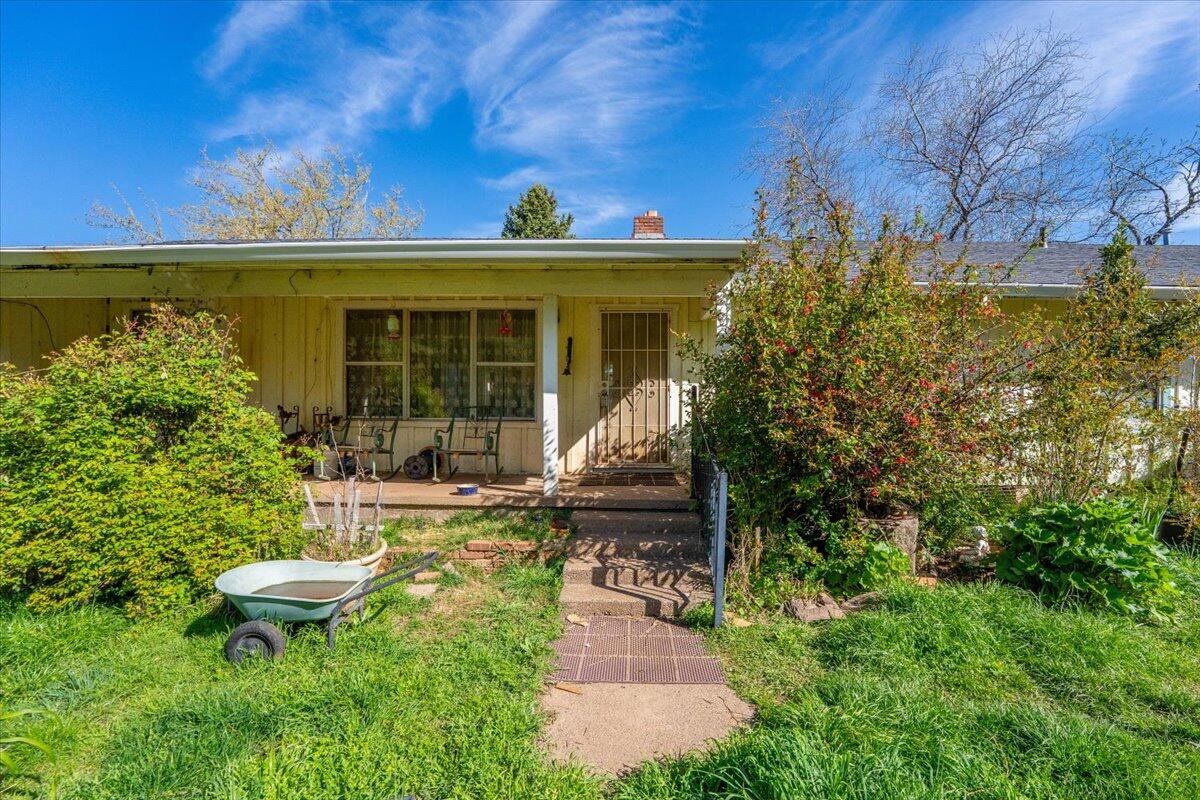 16483 Buzzard Roost Road Bella Vista, CA 96008 - Photo 27 of 138 a view of a patio with table and chairs potted plants and floor to ceiling window