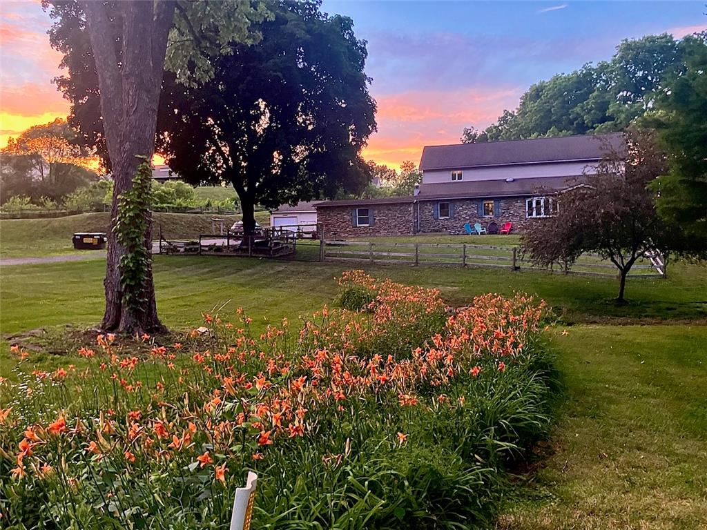 1255 Clearview Road Coplay, PA 18037 - Photo 53 of 54 Mature trees and vibrant perennial gardens frame this multi-level home under a twilight sky.
