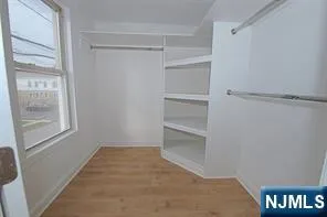 an empty room with windows and cabinet