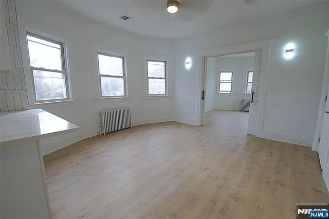 a large white kitchen with white cabinets and a window