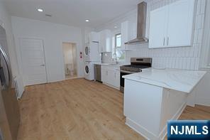 63 Van Winkle Avenue, Unit 2 Garfield, NJ 07026 - Photo 5 of 15 a kitchen with a stove a sink and a refrigerator