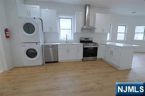 63 Van Winkle Avenue, Unit 2 Garfield, NJ 07026 - Photo 7 of 15 a kitchen with a stove top oven sink and cabinets